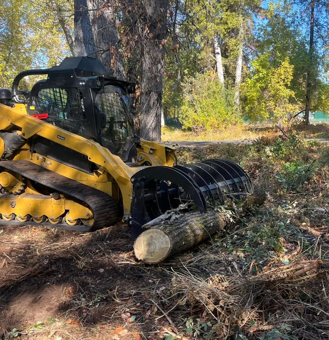Heavy machinery clearing fallen trees and debris during land clearing in Fall River.
